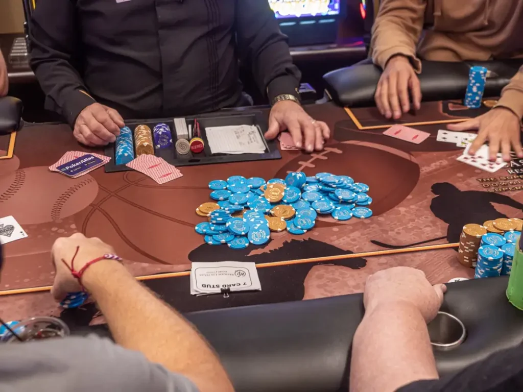 Poker players and a big pile of poker chips during a mixed game in a casino