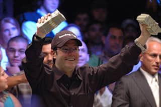 Jamie Gold, winner of the 2006 WSOP Main Event, celebrates with stacks of dollar bills