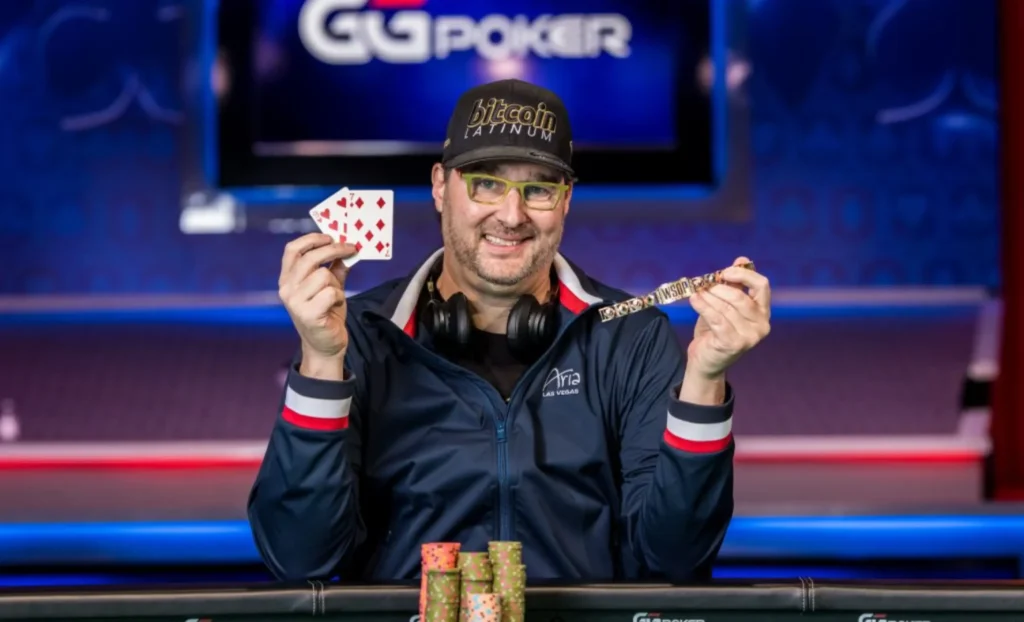 Phil Hellmuth posing with his winning hand and the WSOP bracelet he has just won